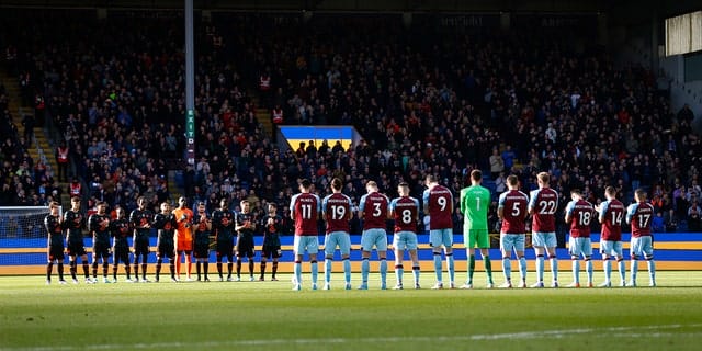 The two teams stand for a minute of applause in support of Ukraine before the Premier League match between Burnley and Chelsea at Turf Moor on March 5, 2022 in Burnley, United Kingdom. 
